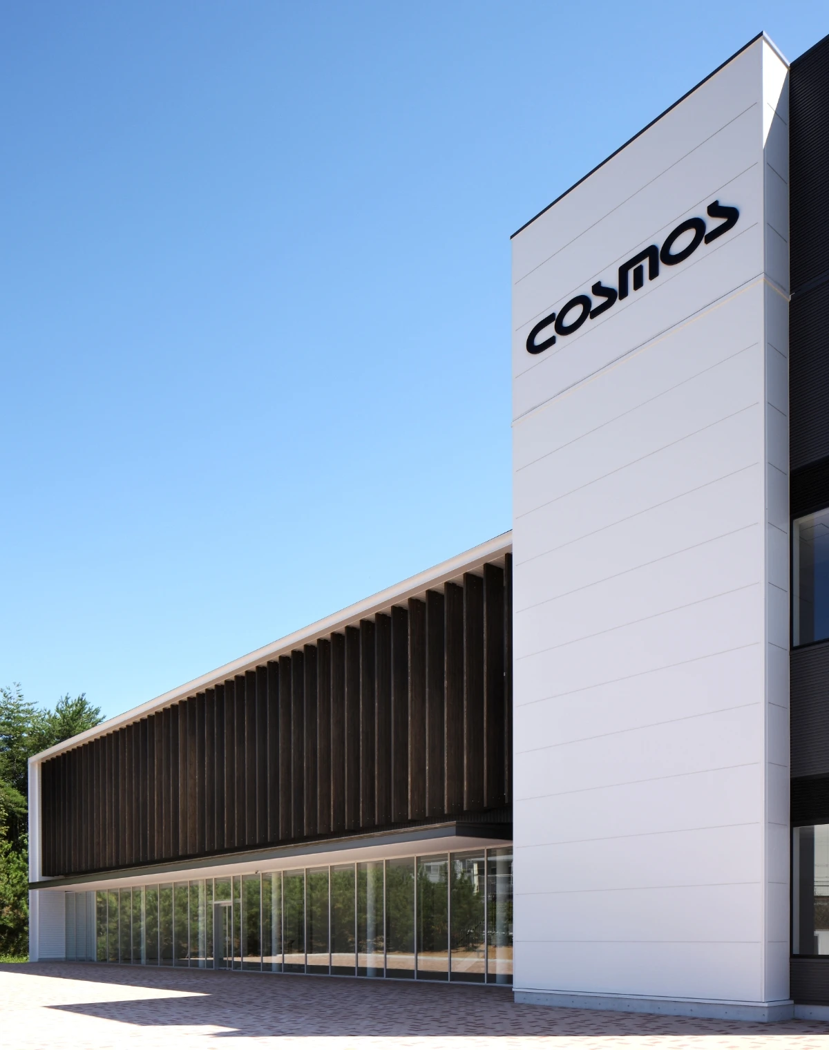 COSMOSのロゴがあるモダンな外観の社屋