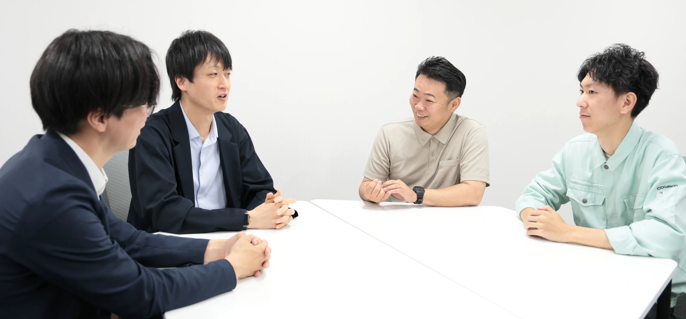 男性社員4名が楽しそうに打ち合わせをしている様子