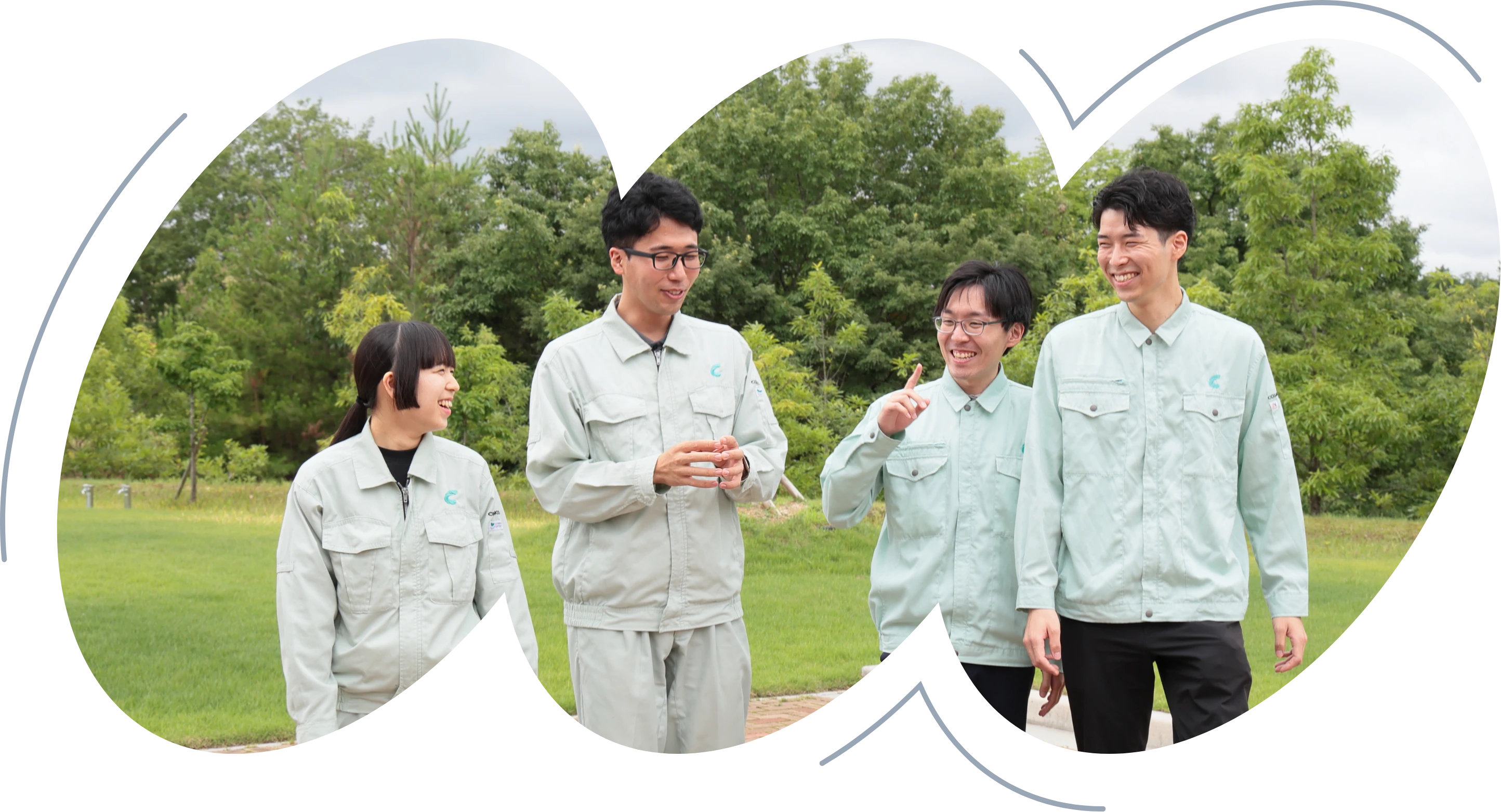COSMOSの制服を着た4名の社員が屋外で談笑しながら歩いている様子